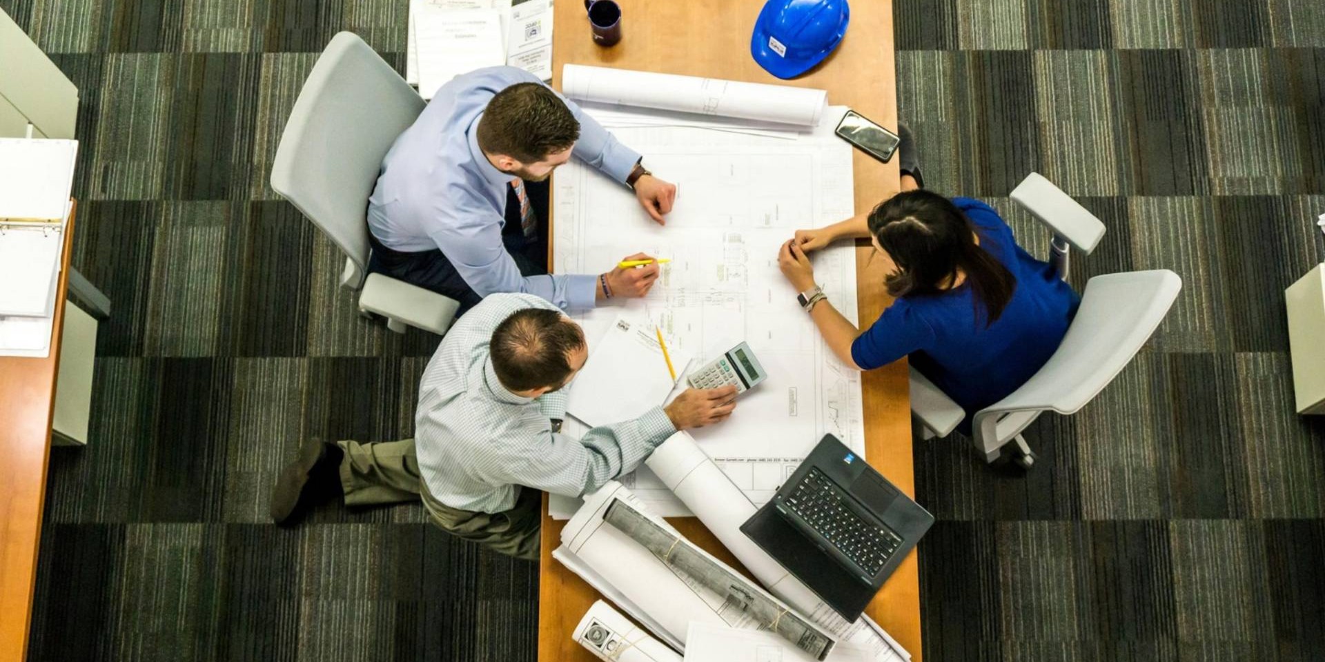 Workplace planning meeting with professionals reviewing documents illustrating organizational consultation and employee assistance services
