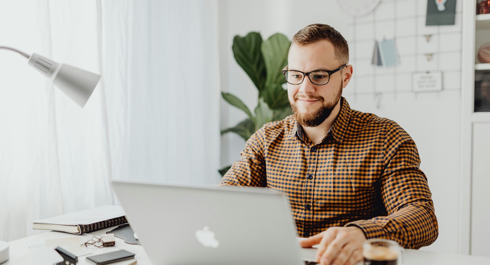 Employee Accessing Workplace Support Resources Through Precedence EAP Professional employee working on a laptop in a home office setting, representing access to Precedence EAP workplace support and mental health resources