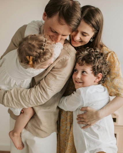 Work-Life Balance and Family Wellness Support Happy family embracing at home, representing work-life balance and family wellness support services provided by Precedence EAP